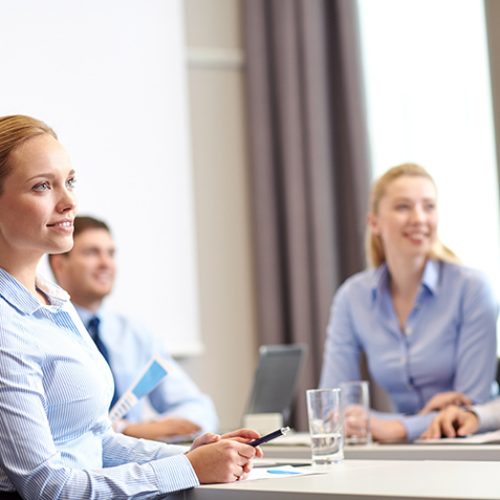 group of smiling businesspeople meeting in office