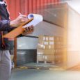 Warehouse worker holding clipboard his control loading package b